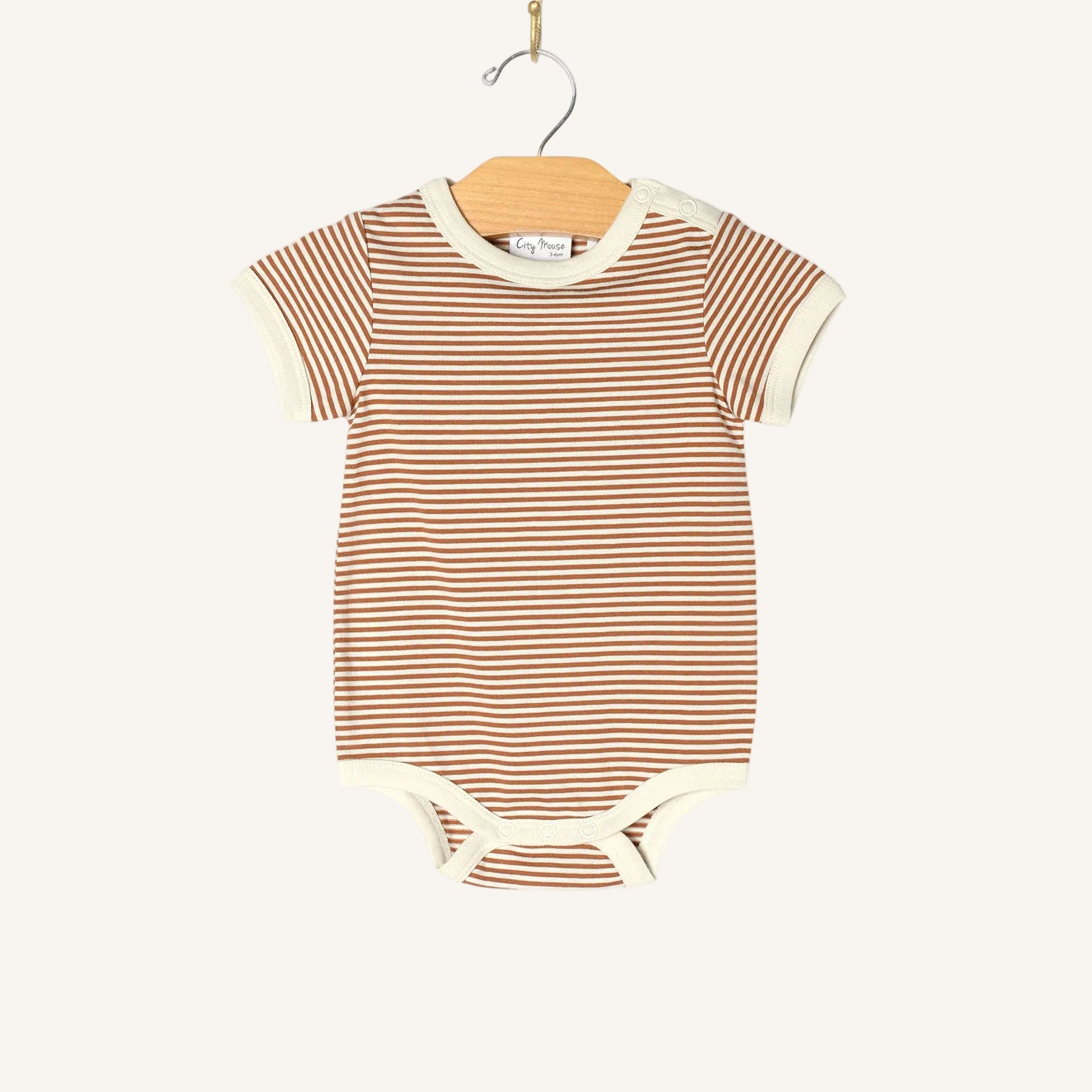 Striped baby bodysuit on a hanger against a white background