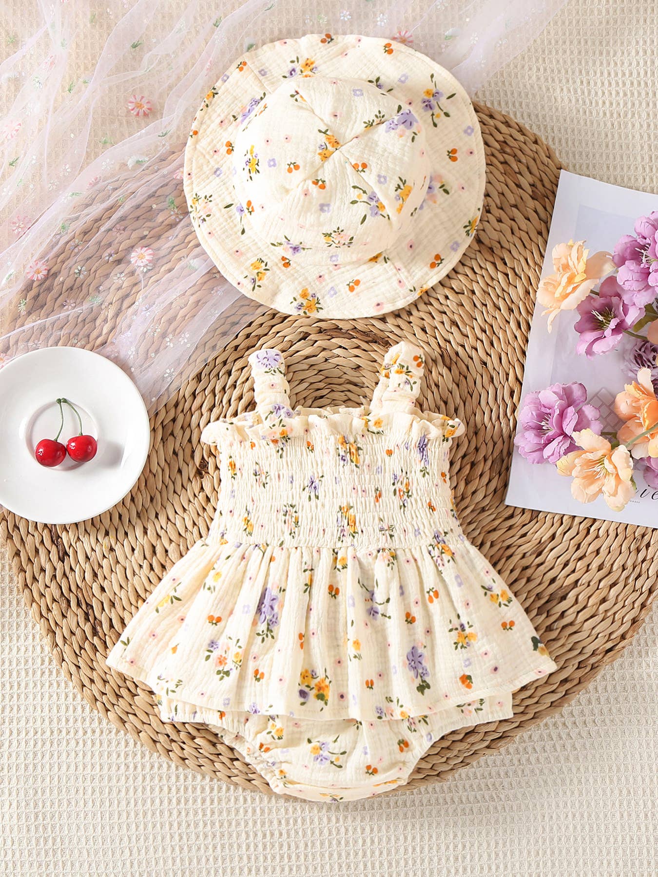 Baby romper and hat with floral pattern on a woven mat