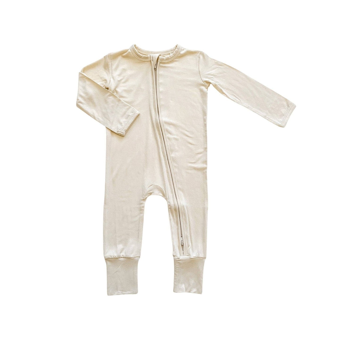 A minimalist baby zipper romper in a solid cream-white color, made from soft bamboo fabric. This long-sleeved one-piece features a full-length center zipper and fold-over foot cuffs. Shown as a clean product flat lay against a bright white background.