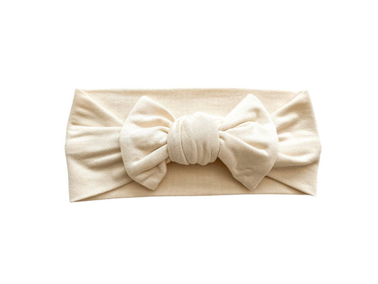 cream white bamboo headband with a large bow on a white background
