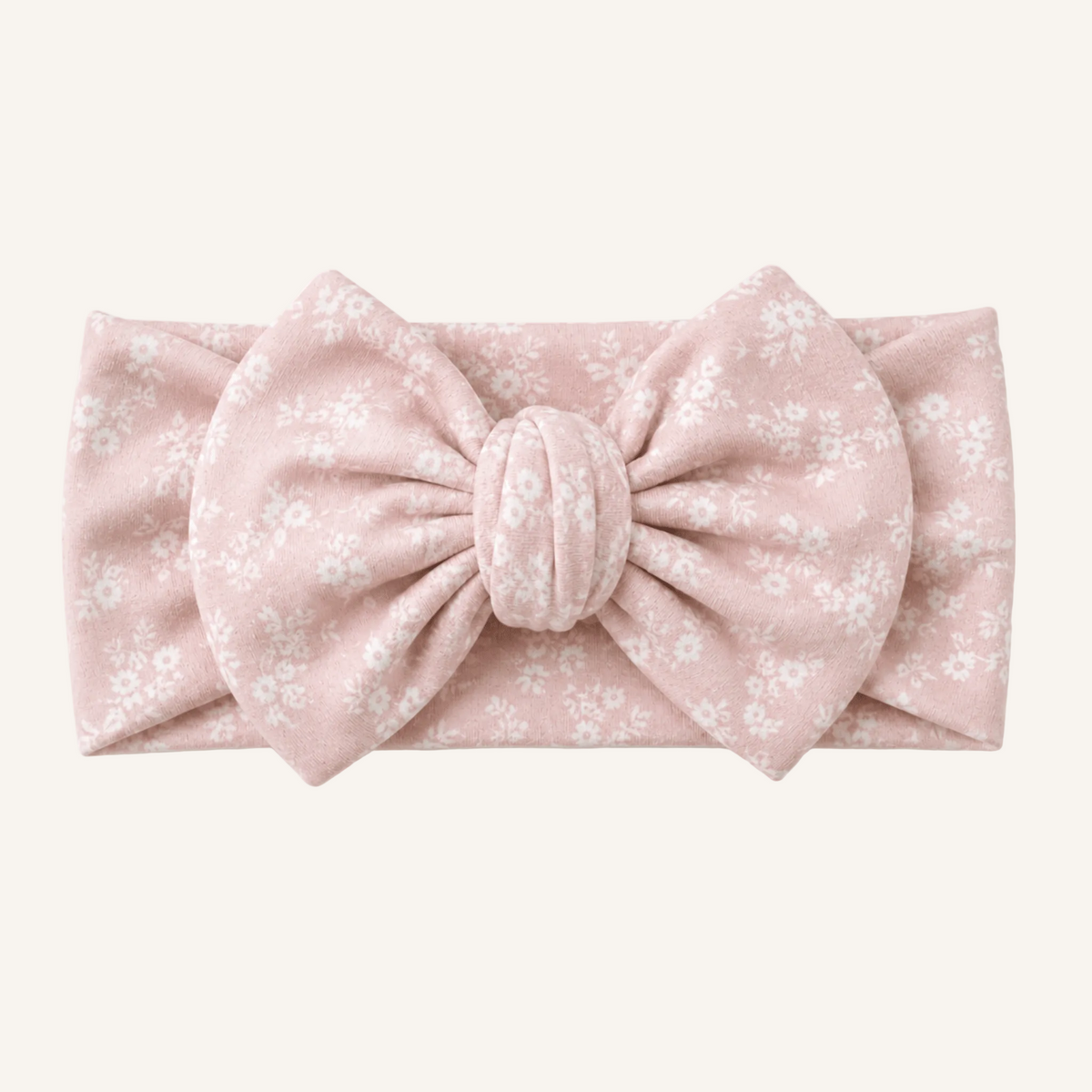 Pink floral headband with a large bow on a white background