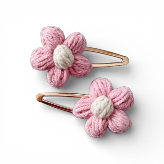 Two pink flower-shaped hair clips on a white background