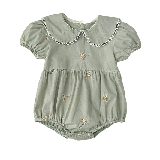 Green baby romper with floral embroidery on a white background