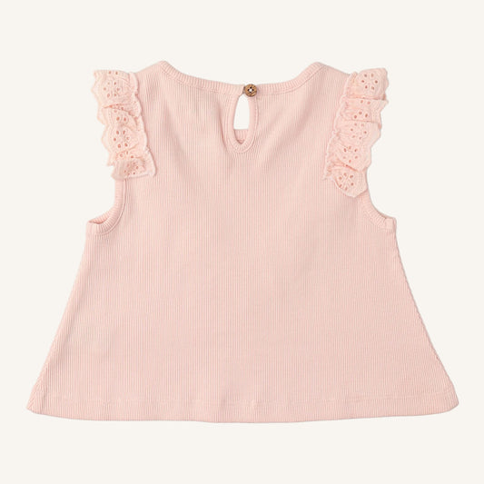 Back of pink ruffled top with wood button on a white background